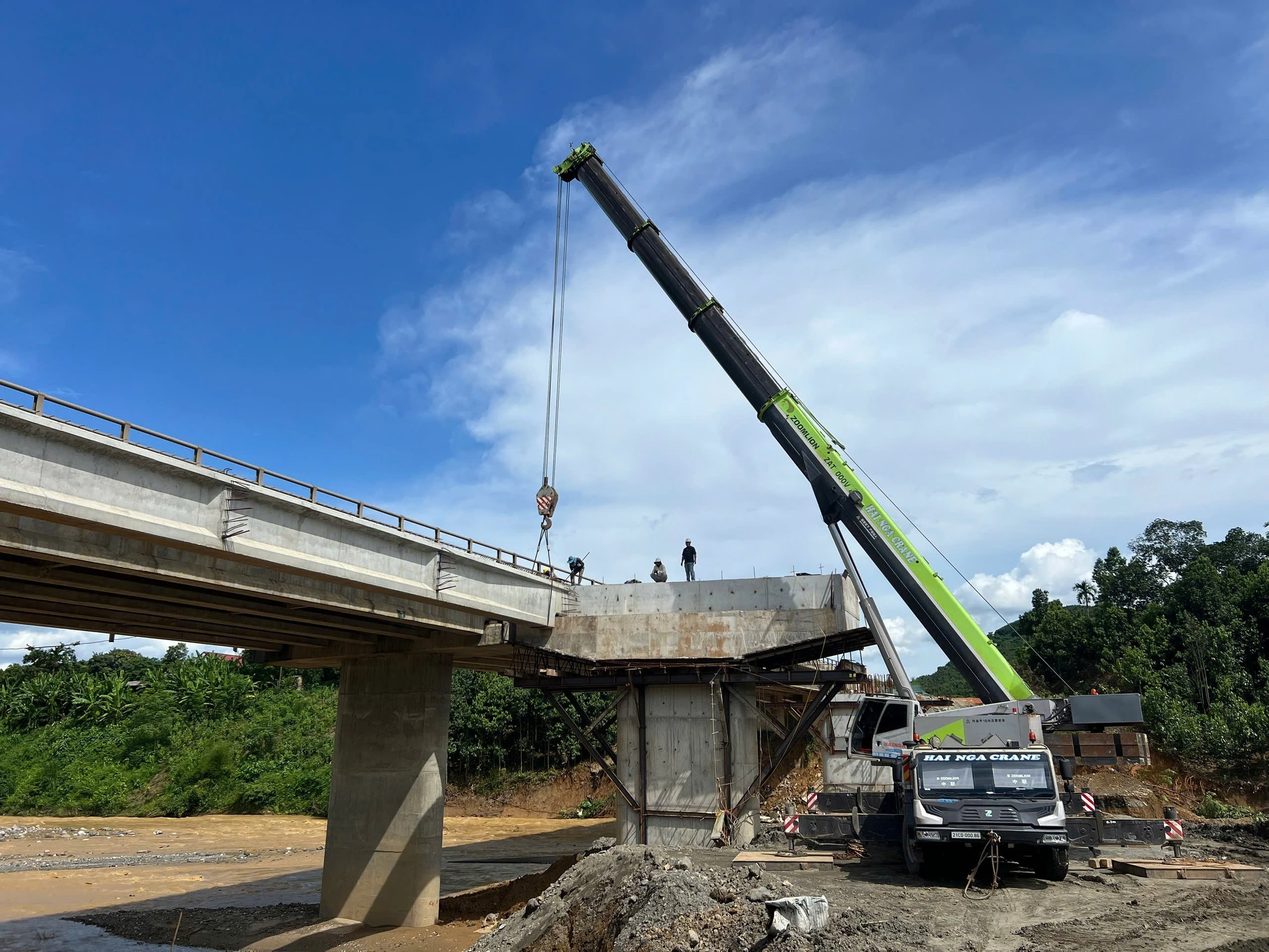 Tại cầu Ngòi Hút (Km165+111), hai cần cẩu trọng tải 110 tấn và 130 tấn đang triển khai gác các phiến dầm bê tông nặng tới 65 tấn vào đúng vị trí.