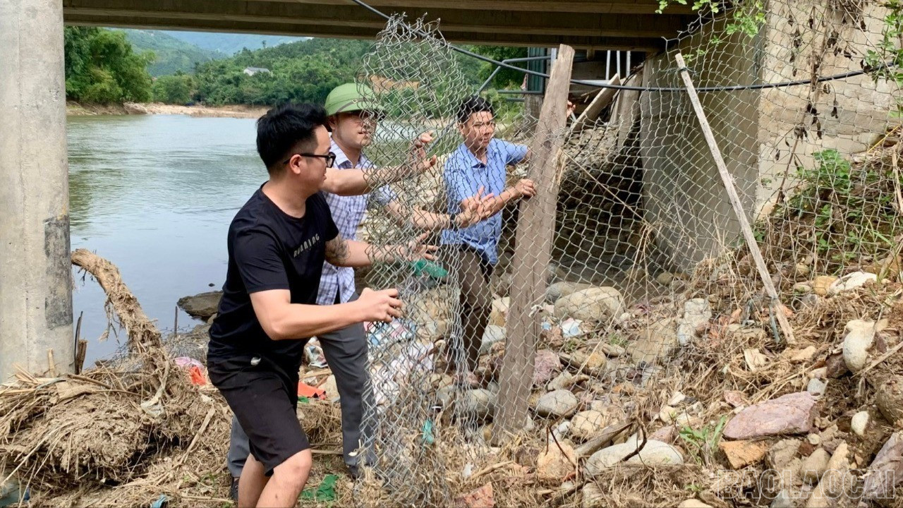 មន្ត្រីឃុំ Phong Du Thuong ជួយគ្រួសារនៅភូមិ Lang Chang ជំនះការខូចខាតដោយទឹកជំនន់។ baolaocai-tl-lanh-dao-xa-2.jpg