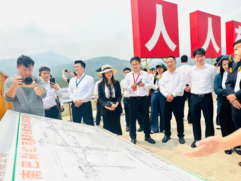 Đoàn công tác của Cục Xúc tiến thương mại (Bộ Công Thương) tìm hiểu tại công trình cầu đường bộ qua sông Hồng.