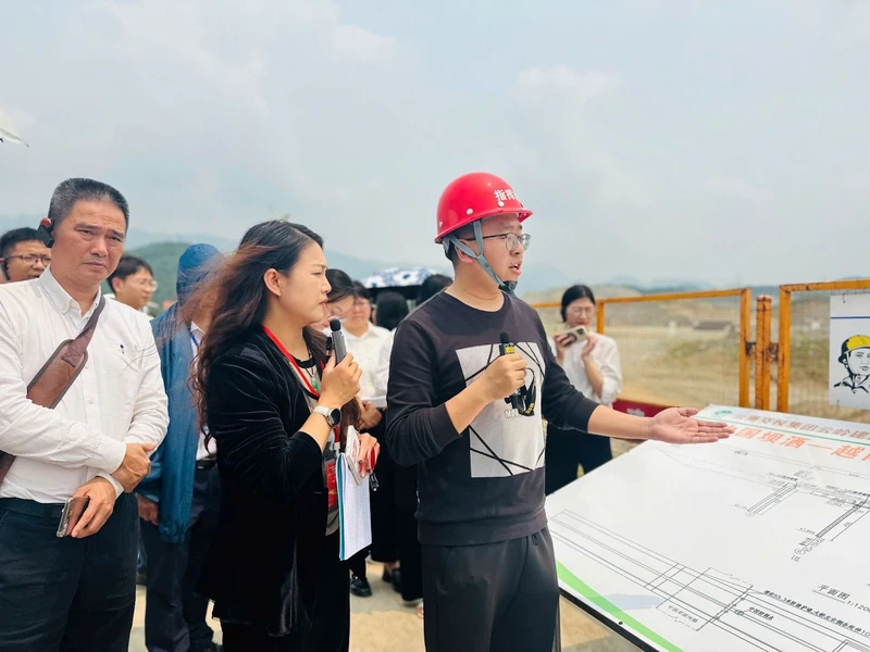 Ông Vương Tân Hồng (mũ đỏ) chia sẻ thông tin về tiến độ dự án đầu cầu Trung Quốc.