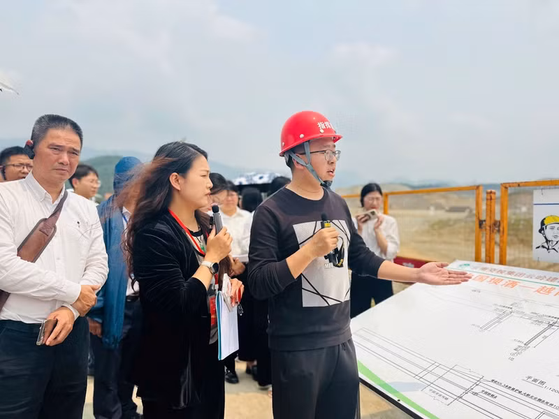 Ông Vương Tân Hồng (mũ đỏ) chia sẻ thông tin về tiến độ dự án đầu cầu Trung Quốc.