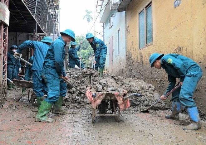 Lực lượng dân quân tự vệ tham gia khắc phục, thu dọn vệ sinh sau khi nước rút tại thành phố Yên Bái.