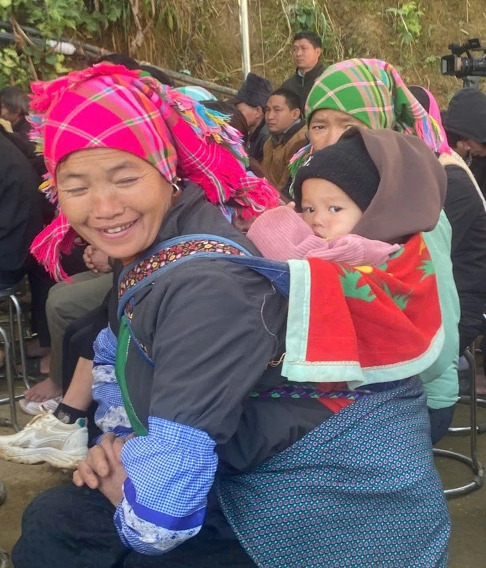 Bà Thèn Thị Xương, dân tộc Nùng, 58 tuổi ở xã Nàn Sán, địu cháu đến nhận quà Tết từ bộ đội biên phòng