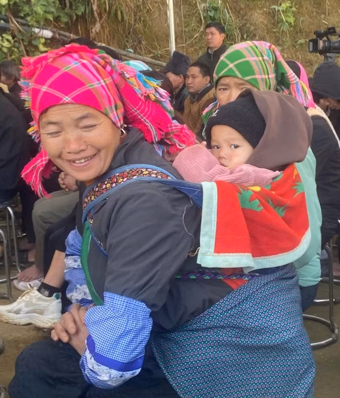 Bà Thèn Thị Xương, dân tộc Nùng, 58 tuổi ở xã Nàn Sán, địu cháu đến nhận quà Tết từ bộ đội biên phòng