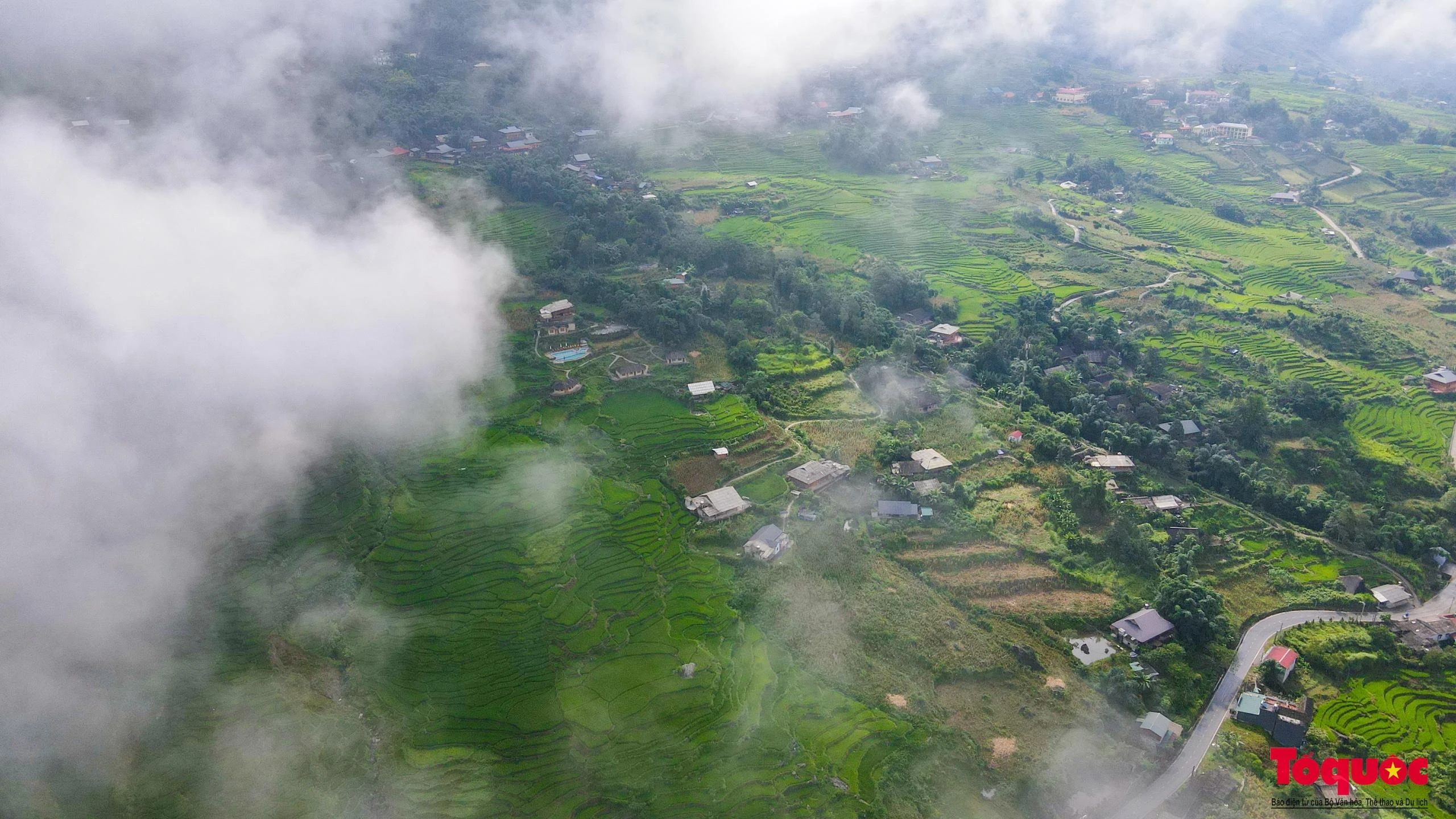 Dưới chân núi, ngôi làng của người Mông thoắt ẩn, thoắt hiện giữa mây mù mờ ảo.