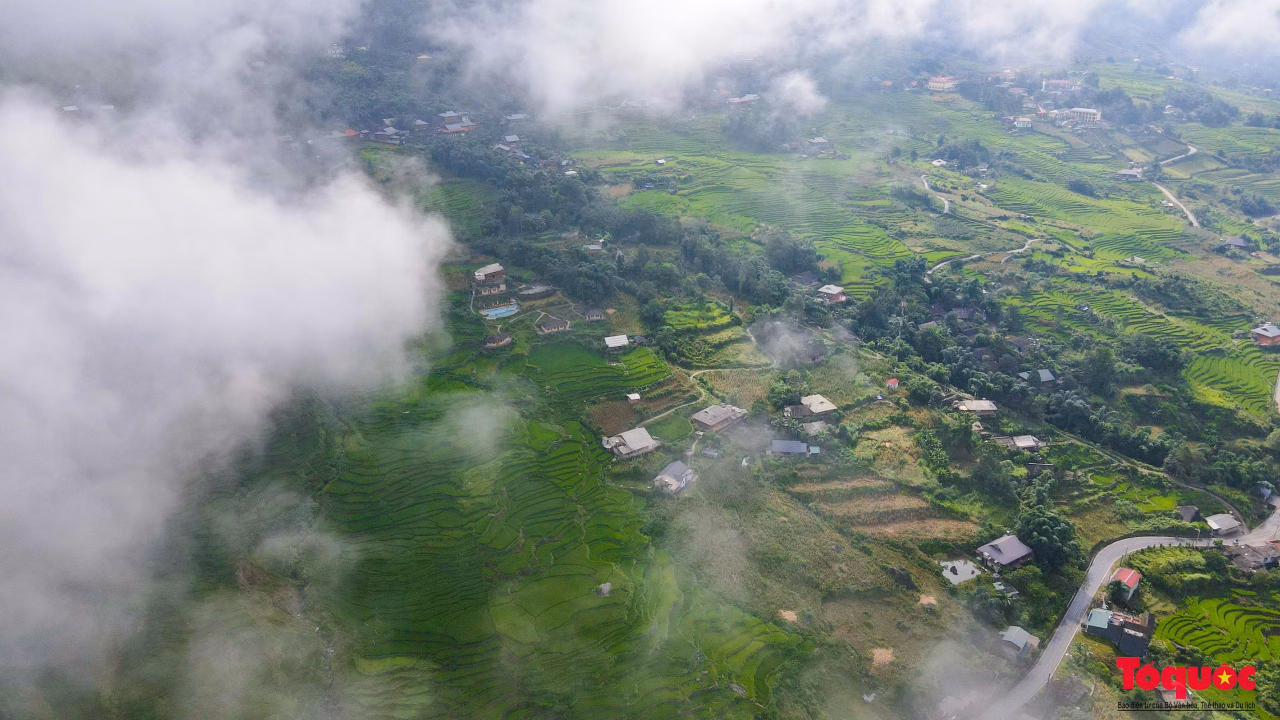 Dưới chân núi, ngôi làng của người Mông thoắt ẩn, thoắt hiện giữa mây mù mờ ảo.
