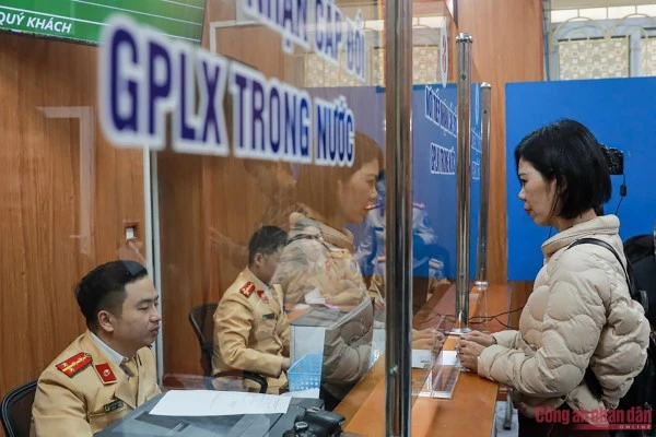 Các cán bộ Công an tiếp nhận hồ sơ cấp đổi GPLX.