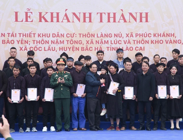 Thủ tướng Phạm Minh Chính và lãnh đạo địa phương trao chứng nhận quyền sử dụng đất tại nơi ở mới cho các gia đình thôn Làng Nủ.