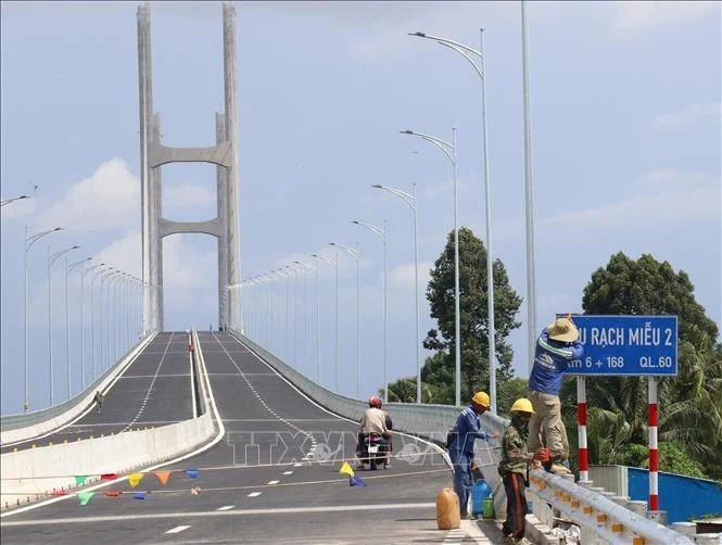 Công nhân đang hoàn tất công đoạn cuối cùng trước khi cầu Rạch Miễu 2 được đưa vào sử dụng.
