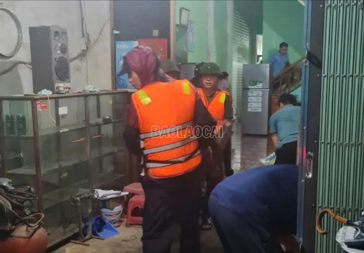 Lực lượng cứu hộ giúp người dân di dời đồ đạc trong đêm mưa lớn.