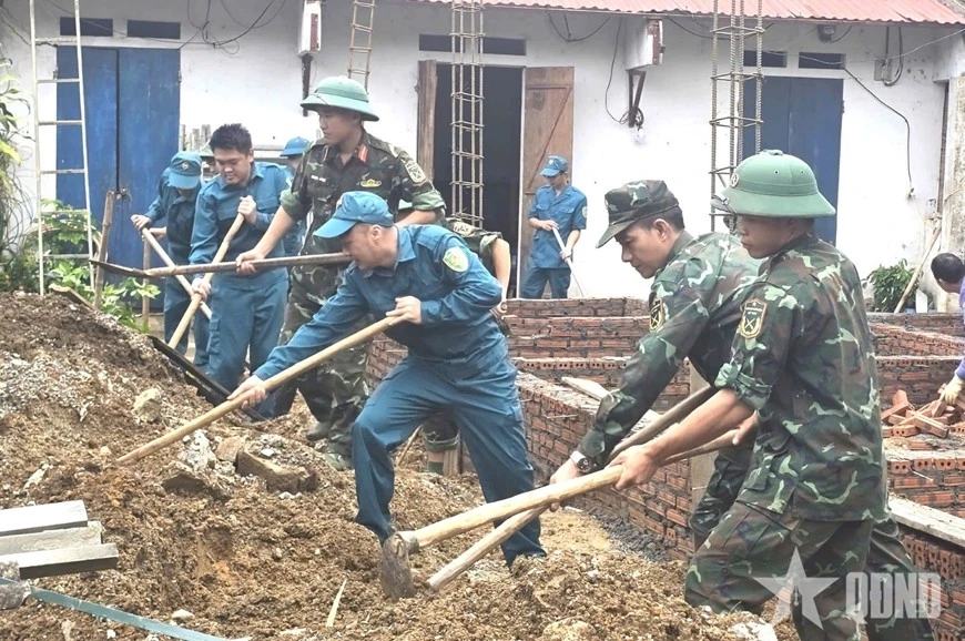 Cán bộ, nhân viên Ban CHQS phường Đoàn Kết (Lai Châu) hỗ trợ gia đình anh Phạm Minh Dương - con đẻ của người tham gia kháng chiến bị nhiễm chất độc hóa học, làm nhà mới.