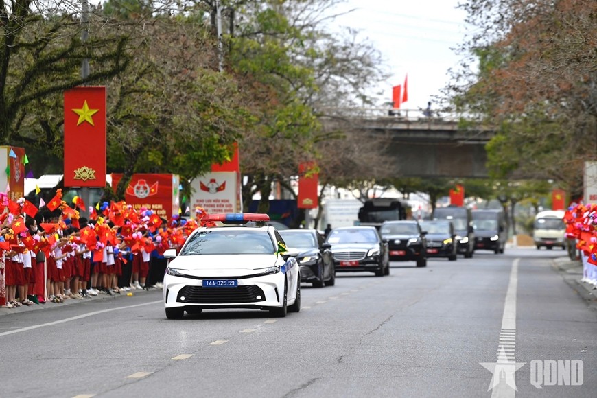 Người dân và các em học sinh chào mừng đoàn xe chở hai Bộ trưởng Bộ Quốc phòng Việt Nam và Trung Quốc.