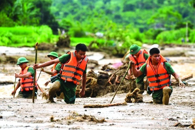 Chiến sĩ Trung đoàn 98 (Sư đoàn Bộ binh 316, Quân khu 2) tìm kiếm người dân mất tích ở Làng Nủ (Lào Cai) bị vùi lấp bởi lũ quét, sạt lở, tháng 9/2024.