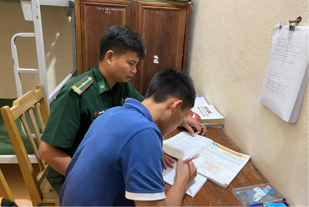 Cán bộ Đồn Biên phòng Si Ma Cai, BĐBP Lào Cai hướng dẫn con nuôi của đơn vị học bài.