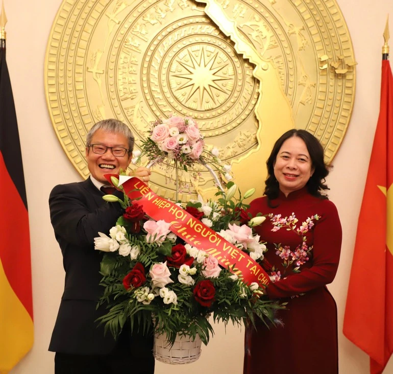 Quyền Chủ tịch Liên hiệp hội người Việt Nam tại CHLB Đức, Tiến sĩ Nguyễn Xuân Thính (bên trái) tặng hoa Phó Chủ tịch nước Võ Thị Ánh Xuân.