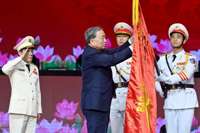 Tổng Bí thư Tô Lâm gắn Huân chương Sao Vàng lên lá cờ truyền thống của Lực lượng Công an nhân dân Việt Nam.