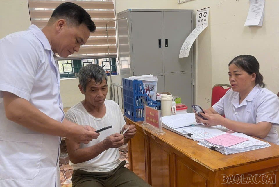 Đồng chí Lục Văn An - Phó trưởng trạm phụ trách Phân trạm Làng Giàng hướng dẫn người dân truy cập VNeID mức độ 2 để kiểm tra sổ khám sức khỏe điện tử. baolaocai-br_3815366936239793996.jpg