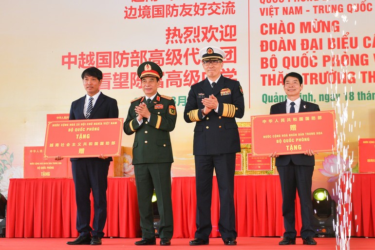 Đại tướng Phan Văn Giang, Ủy viên Bộ Chính trị, Phó Bí thư Quân ủy Trung ương, Bộ trưởng Quốc phòng và Thượng tướng Đổng Quân, Bộ trưởng Quốc phòng Trung Quốc trao quà cho đại diện nhà trường.