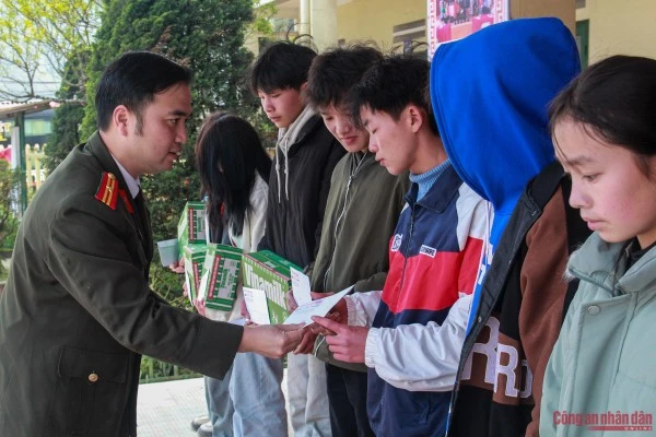 Thiếu tá Trần Quang Huy, Chủ tịch Công đoàn Báo CAND trao quà cho các em học sinh.