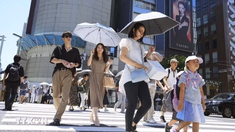 Người dân che ô tránh nắng nóng trên đường phố tại Tokyo, Nhật Bản.