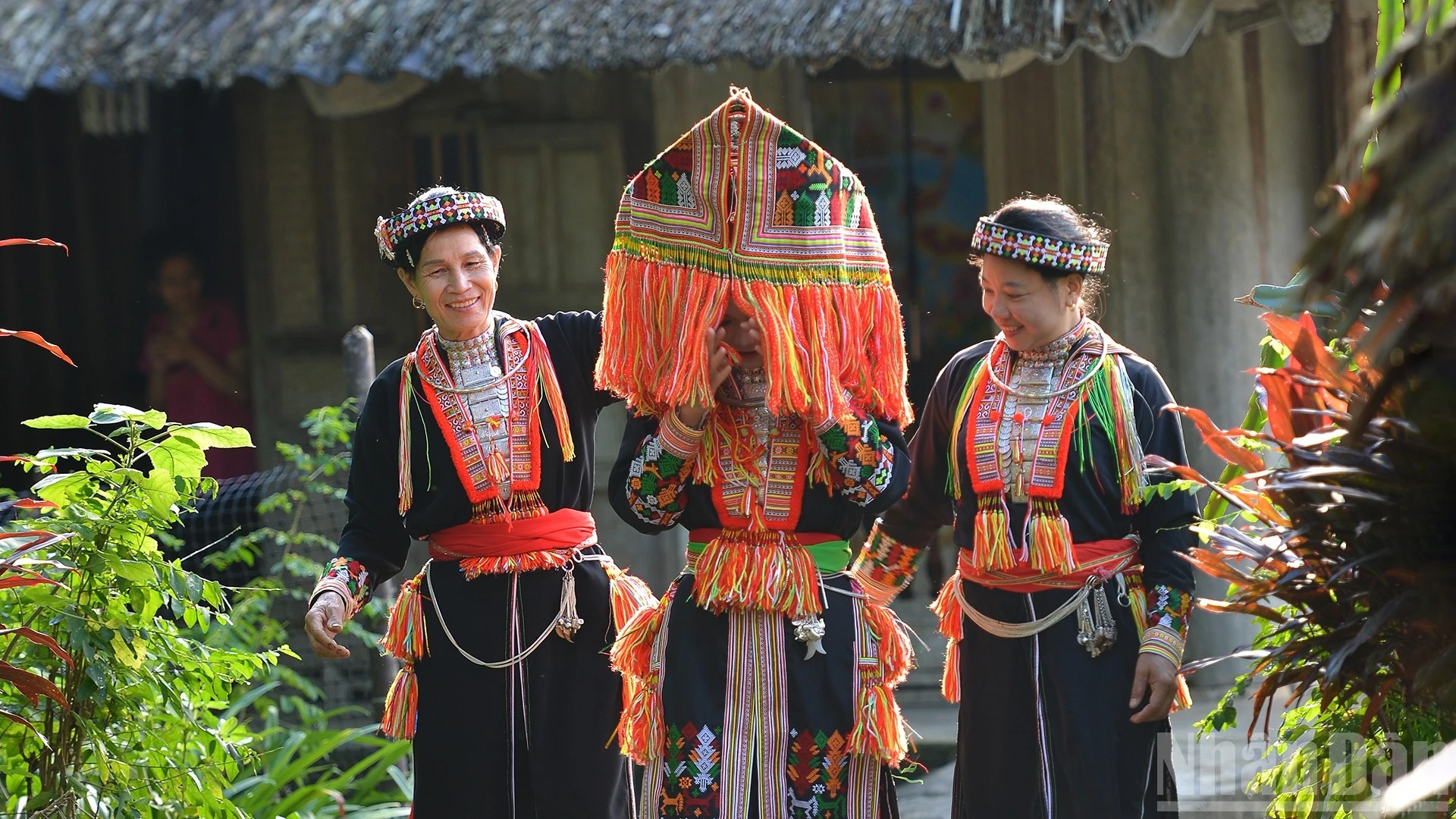 Mũ trùm kín đầu đính tua chỉ sặc sỡ.