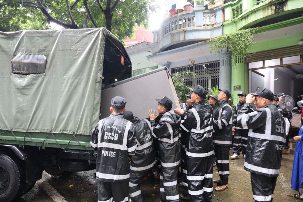 Lực lượng cảnh sát cơ động hỗ trợ người dân di chuyển tài sản.