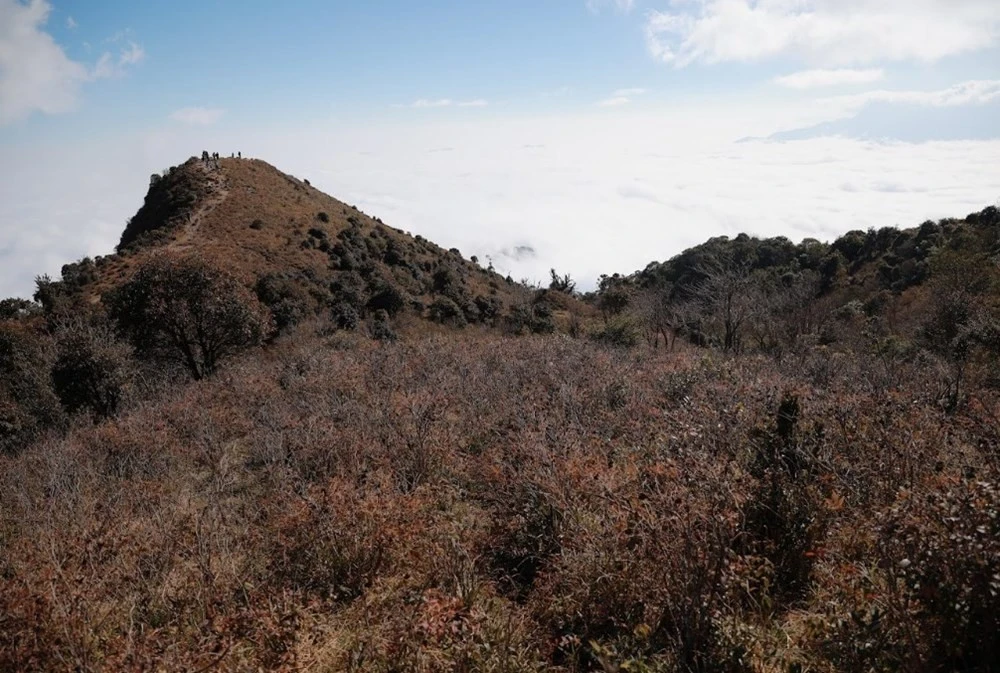 Sống núi uốn lượn như lưng khủng long giữa mây trời.