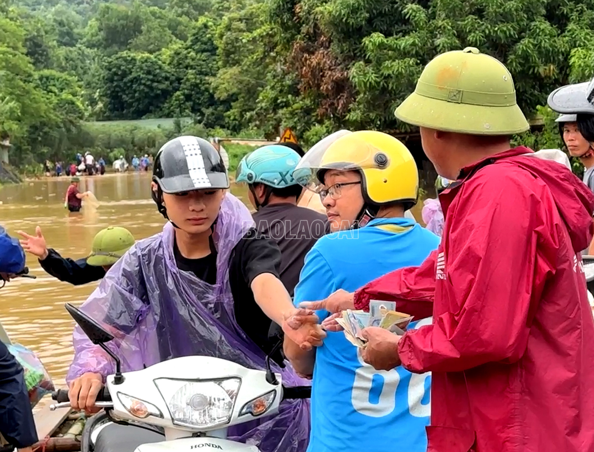 Người đi đường trả tiền để được hỗ trợ đi qua điểm ngập úng. tt3.jpg