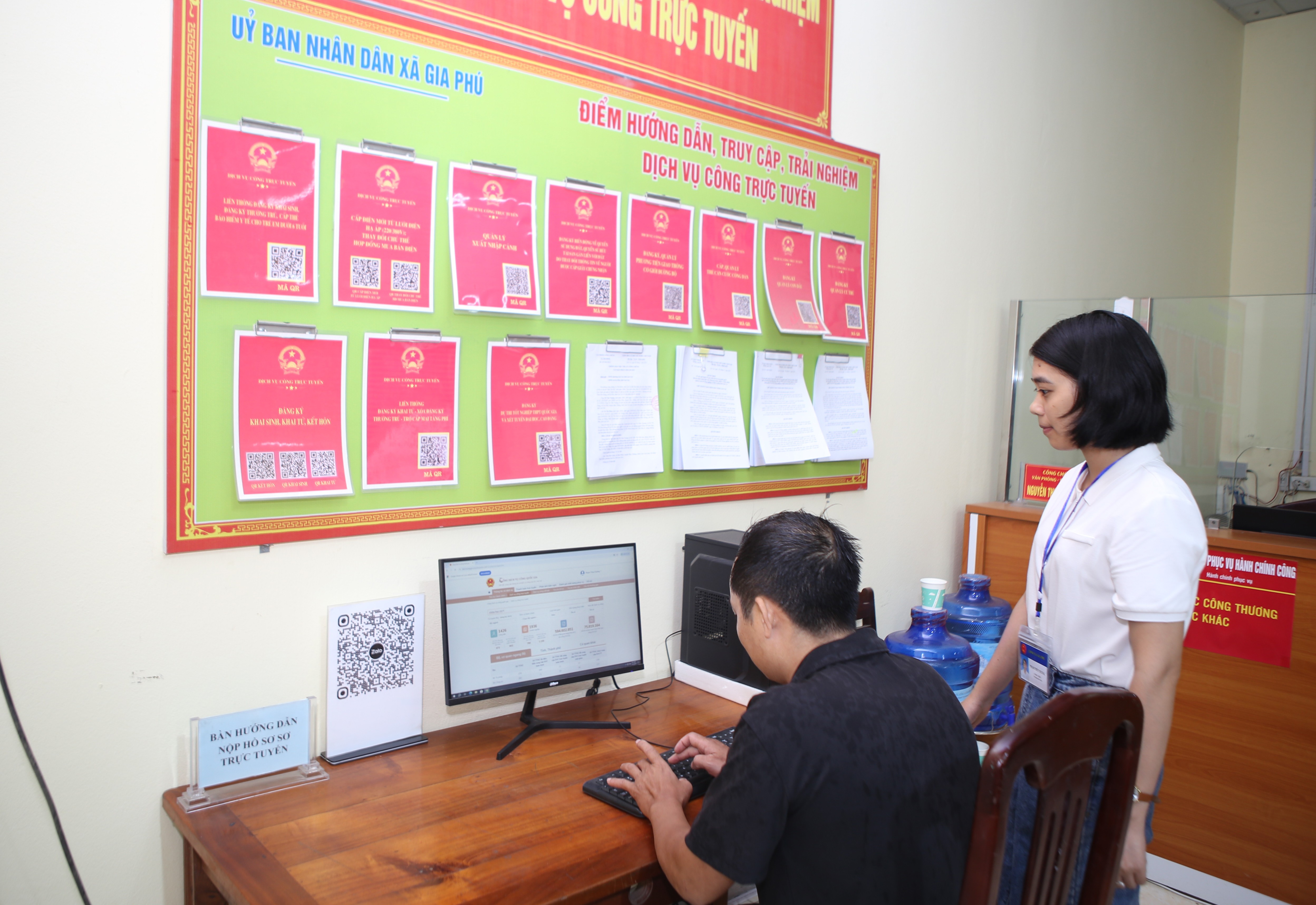 Lãnh đạo, cán bộ xã giải đáp vướng mắc và hướng dẫn người dân thực hiện thủ tục hành chính trực tuyến trên cổng dịch vụ công. 5-8590.jpg
