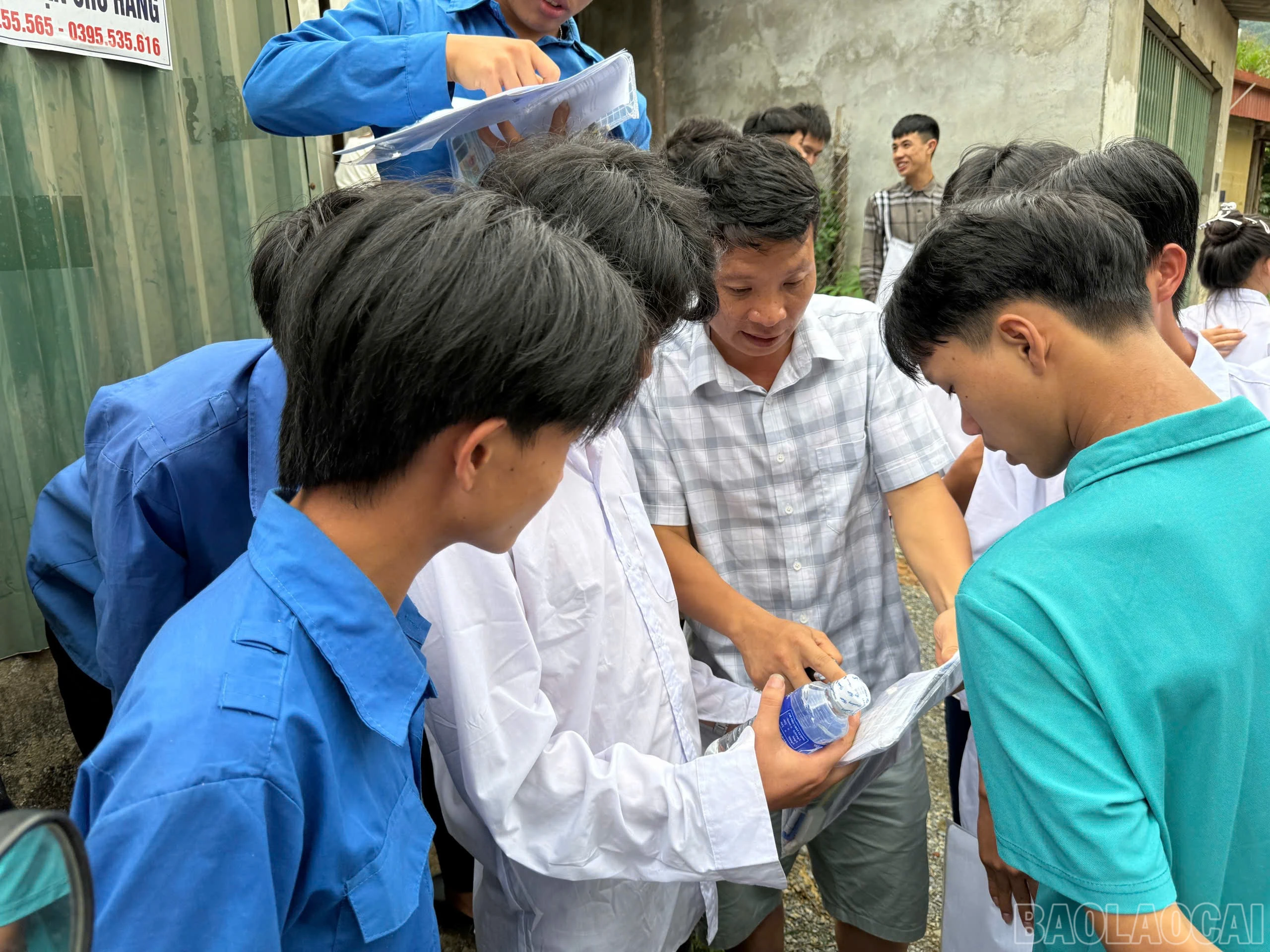 Thí sinh trao đổi đề thi với thầy giáo.