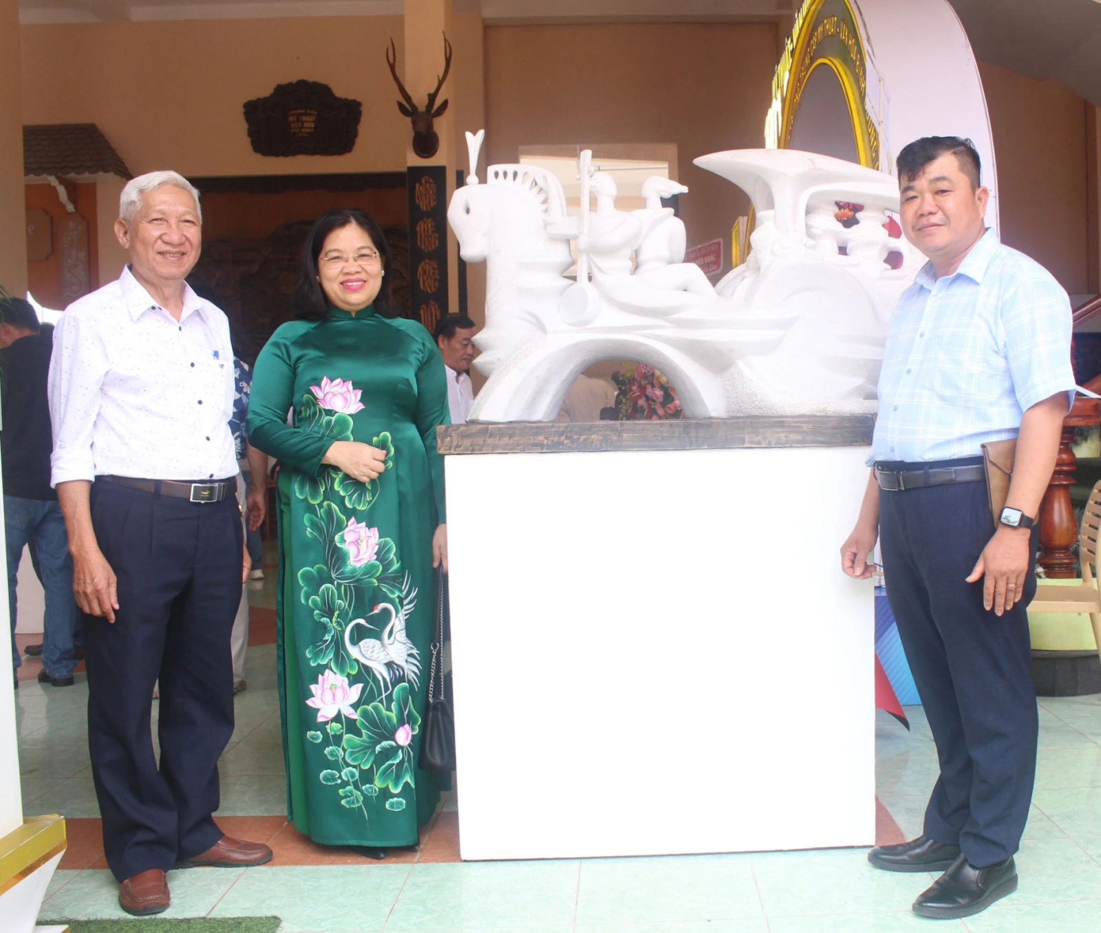 Lãnh đạo HĐND tỉnh và Chủ tịch Hội Văn học - Nghệ thuật tỉnh chụp ảnh cùng nhà điêu khắc Châu Trâm Anh (bìa phải) bên cạnh tác phẩm “Tình ca phương Nam”