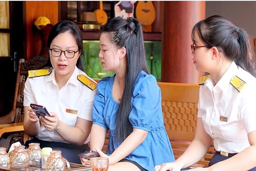 Cán bộ ngành thuế hướng dẫn hộ kinh doanh chuyển đổi mô hình từ thuế khoán sang kê khai. Ảnh: HUY HÙNG