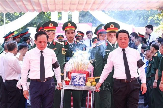 Trưởng Ban Tuyên giáo và Dân vận Trung ương Trịnh Văn Quyết, Bí thư Tỉnh uỷ Tuyên Quang Hầu A Lềnh và các đại biểu thực hiện nghi thức đưa các liệt sĩ về nơi an nghỉ cuối cùng. Ảnh: Hoàng Hiếu/TTXVN