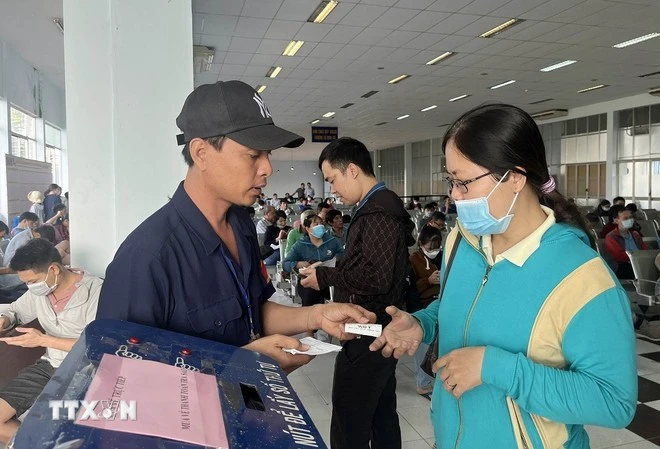 Hành khách lấy số thứ tự mua vé tàu Tết tại ga Sài Gòn.