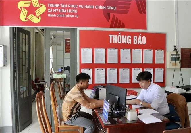 Người dân đến Trung tâm phục vụ hành chính công xã Mỹ Hoà Hưng, tỉnh An Giang làm thủ tục hành chính. Ảnh: Thanh Sang/TTXVN