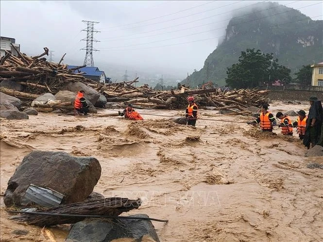 Trận lũ ống sáng 17/7/2026 quét qua xã Mường Than (tỉnh Lai Châu) đã gây thiệt hại nghiêm trọng tại nhiều khu vực của vùng quê bình yên này. Nhà cửa bị vùi lấp trong đất đá, cây cối gãy đổ, bùn đất phủ kín khắp các con đường. Trong ảnh: Lực lượng Công an Lai Châu hỗ trợ cứu người bị cô lập về nơi an toàn. Ảnh: Quý Trung/TTXVN.