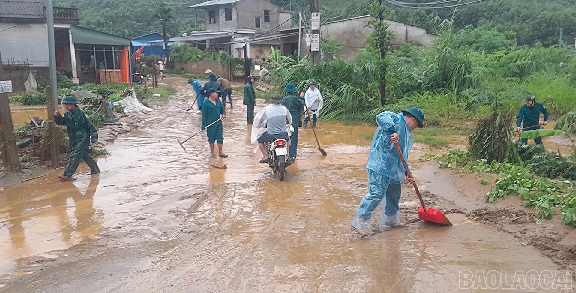 Lực lượng dân quân tham gia cùng người dân vệ sinh đường phố.