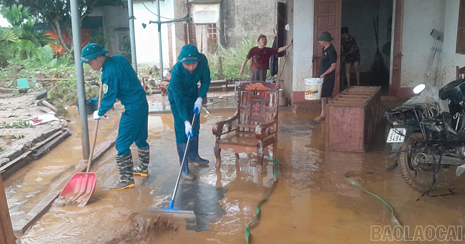 Lực lượng dân quân tham gia giúp dân dọn dẹp nhà cửa sau khi nước rút.