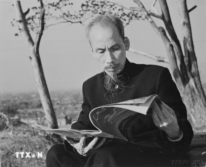 Chủ tịch Hồ Chí Minh đọc báo trước ngôi nhà nghỉ của Người khi sang thăm Trung Quốc, năm 1953.