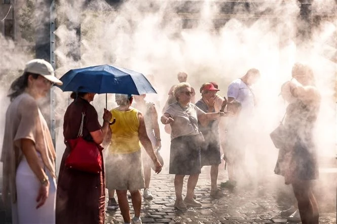 Người dân làm mát dưới hệ thống phun sương ở Budapest, Hungary. THX/TTXVN phát