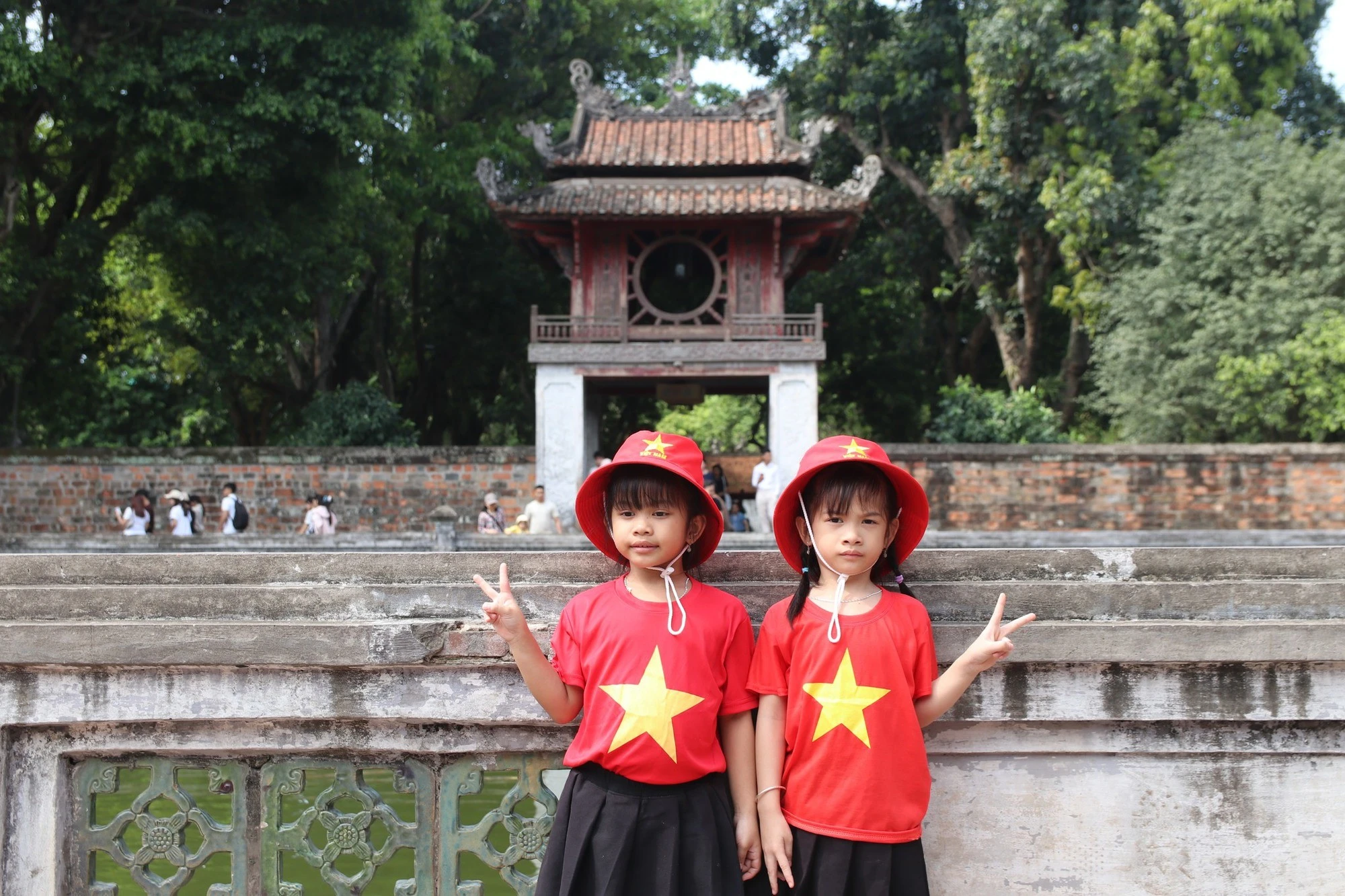Các em nhỏ mặc áo đỏ sao vàng đến thăm Quốc Tử Giám