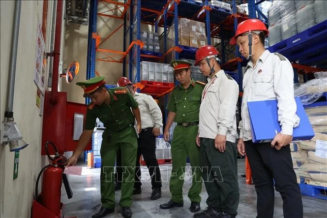 Cán bộ Đội CC và CNCH khu vực 21 (TP. Hồ Chí Minh) kiểm tra bình chữa cháy mini trong nhà xưởng doanh nghiệp. Ảnh minh họa: Hồng Đạt/TTXVN