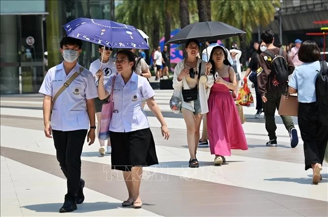 Người dân che ô tránh nắng nóng tại Bangkok, Thái Lan.