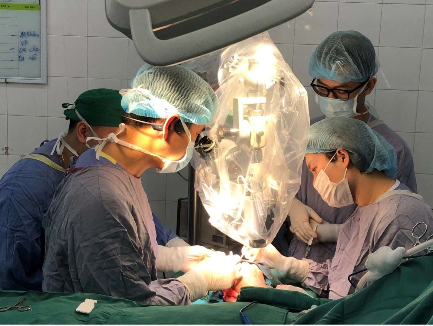 Kíp mổ thực hiện vi phẫu nối lại ngón tay cho người bệnh với kính hiển vi.