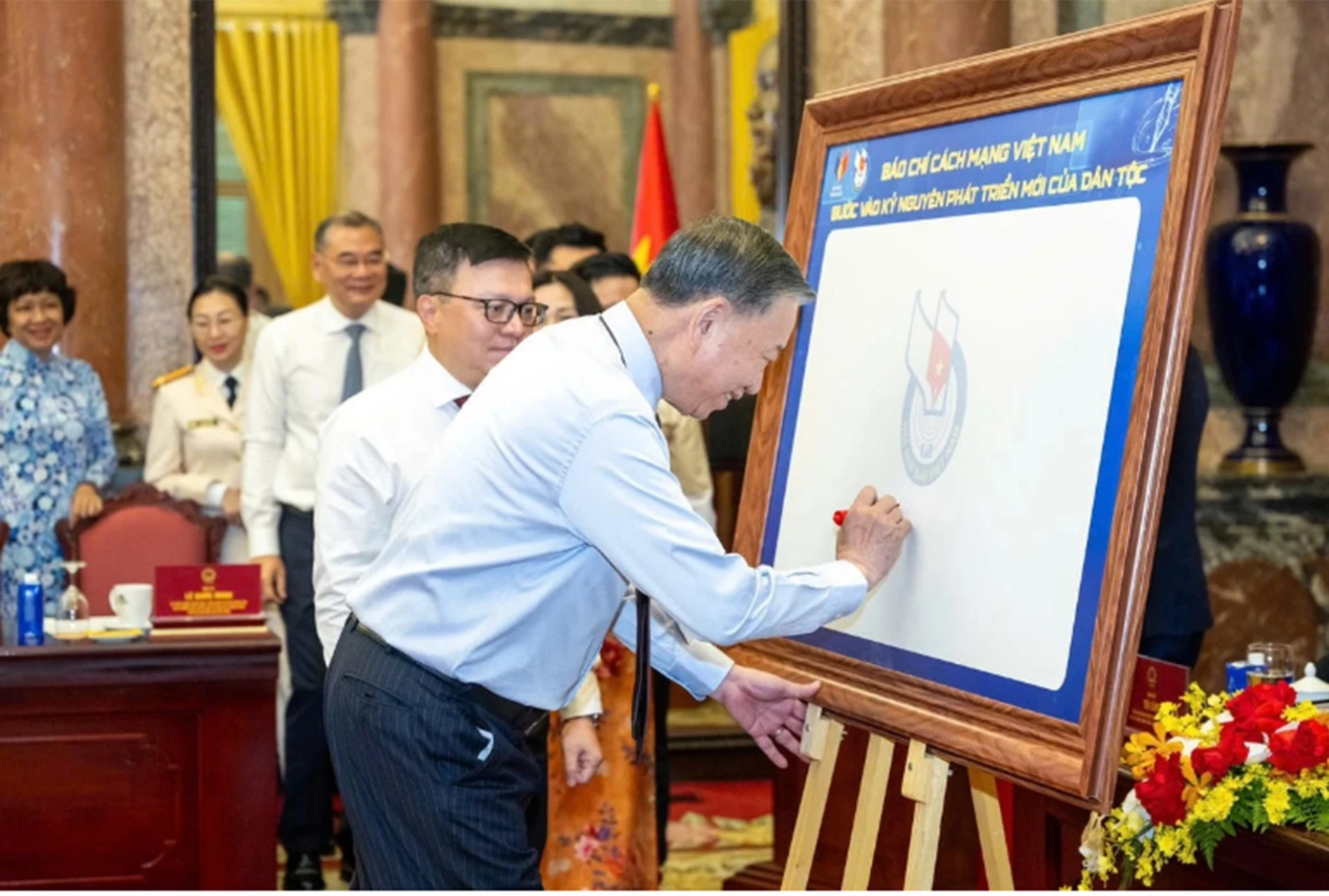 Tổng Bí thư, Chủ tịch nước Tô Lâm ký lưu niệm vào biểu trưng của Hội Nhà báo Việt Nam tại buổi gặp mặt 101 nhà báo tiêu biểu đoạt Giải Báo chí Quốc gia qua các năm, nhân dịp kỷ niệm 101 năm ngày Báo chí cách mạng Việt Nam (21/6/1925 – 21/6/2026).