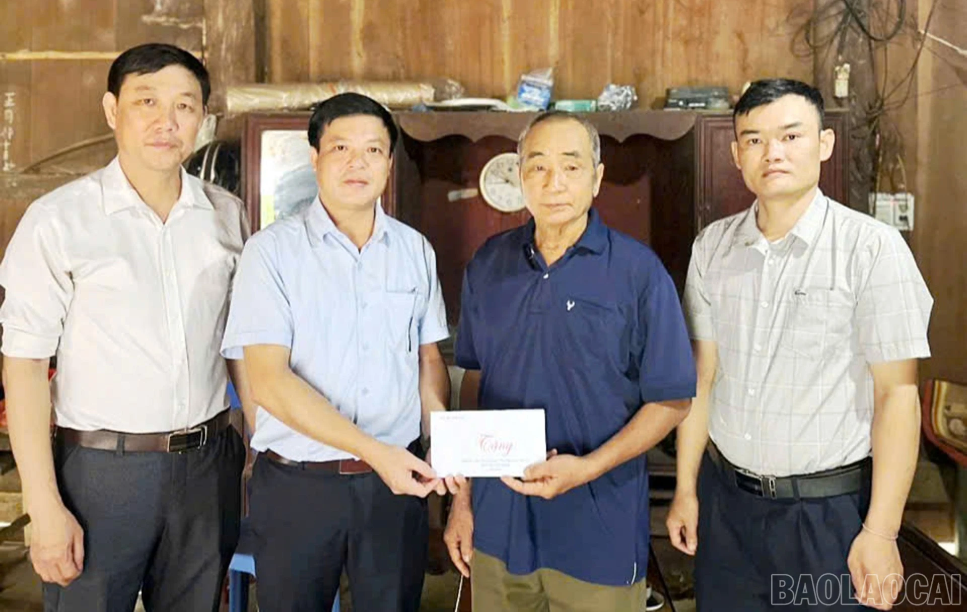 Lãnh đạo xã Mỏ Vàng trao tặng các phần quà của Đảng, Nhà nước, tỉnh Lào Cai và của xã tới các gia đình chính sách.