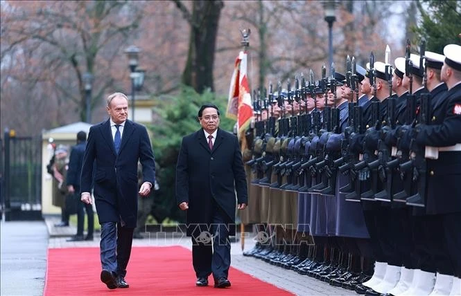 Thủ tướng Phạm Minh Chính và Thủ tướng Cộng hòa Ba Lan Donald Tusk duyệt đội danh dự. Ảnh: Dương Giang/TTXVN