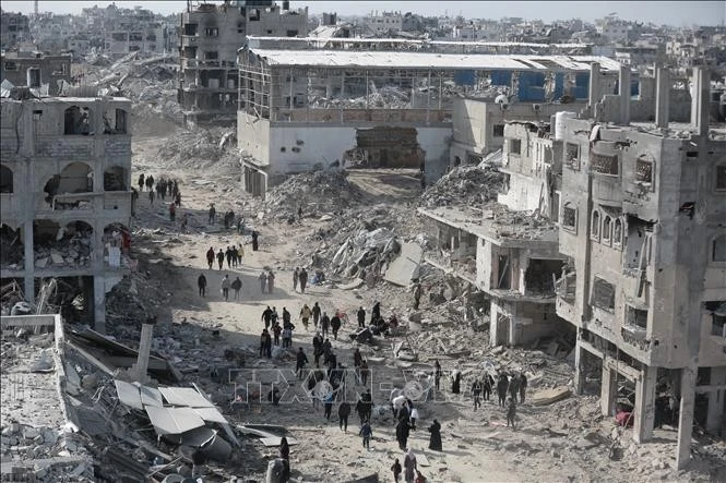 Người dân Palestine di chuyển trong thành phố đổ nát vì xung đột giữa Phong trào Hamas và Israel ở phía Bắc Dải Gaza. Ảnh: THX/TTXVN