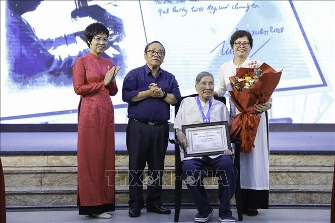 Tổng Giám đốc TTXVN Vũ Việt Trang và Phó Chủ tịch Hội Nhà văn Việt Nam, Chủ tịch Hội đồng giám khảo Trần Đăng Khoa trao giải "Hiệp sĩ Dế Mèn" cho nhạc sĩ Phạm Tuyên. Ảnh: Lê Đông/TTXVN