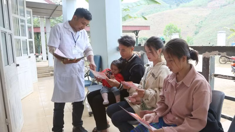 Cán bộ Trạm Y tế Tân Xuân, xã Xuân Nha, tỉnh Sơn La, phát tờ rơi tuyên truyền về giảm thiểu mất cân bằng giới tính khi sinh.